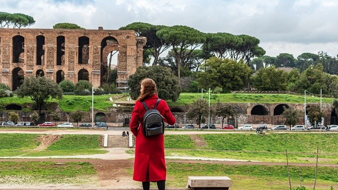 Young girl in front of Colosseum in Rome in February In Rome in February, it's warm and sunny